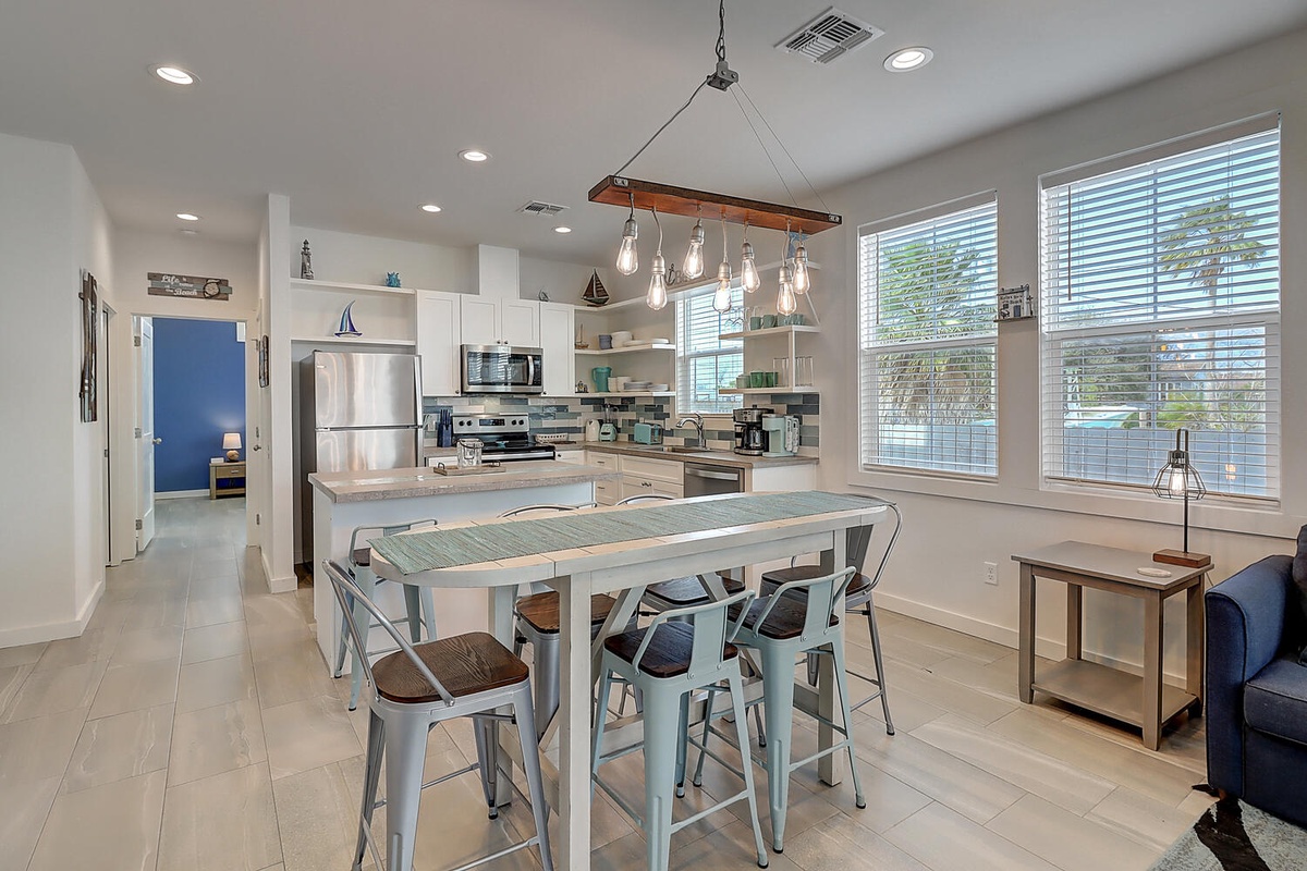 Your modern kitchen features sleek appliances, stylish pendant lighting, and a welcoming breakfast bar perfect for morning coffee.