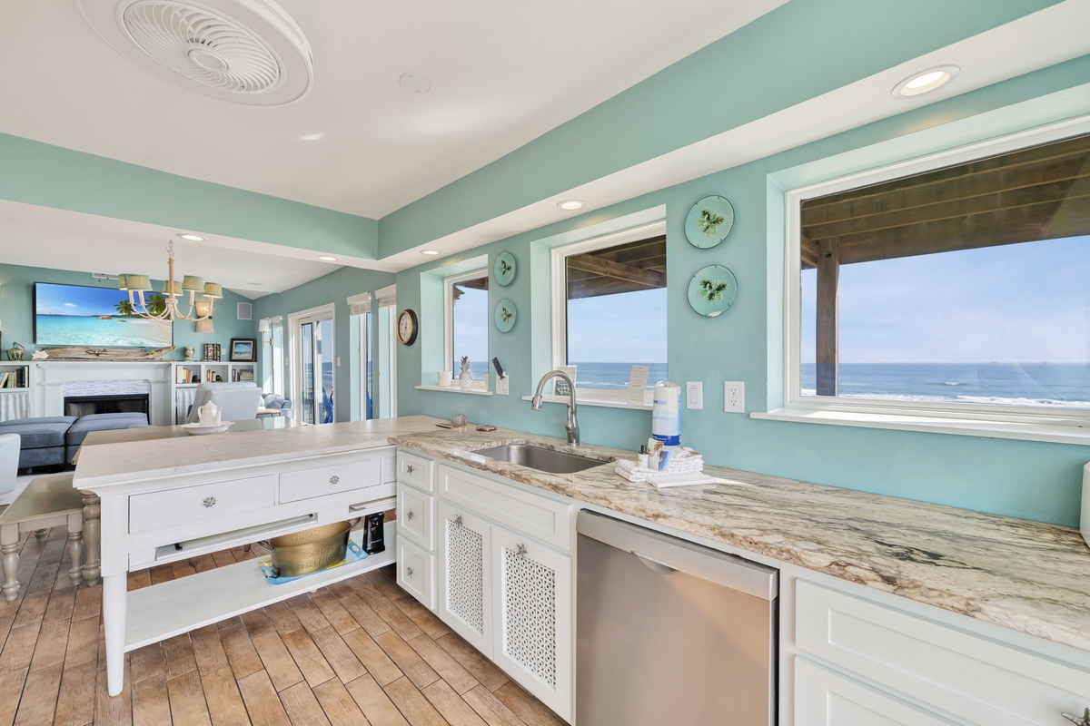 Your coastal kitchen combines beautiful marble counters with serene ocean views, perfect for preparing meals while watching waves.