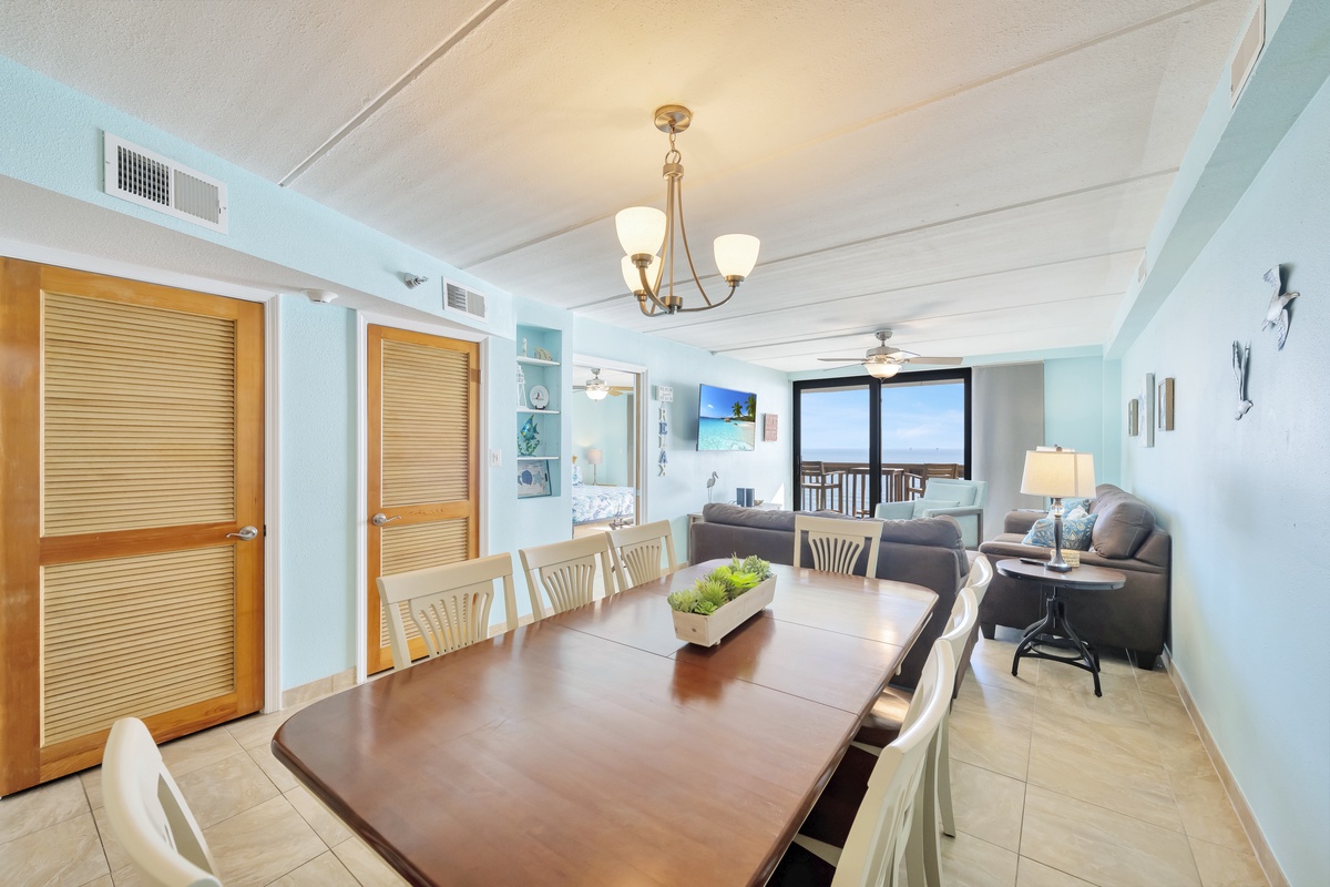 Your open living space flows beautifully from dining to living room, all bathed in ocean views and soft coastal colors.