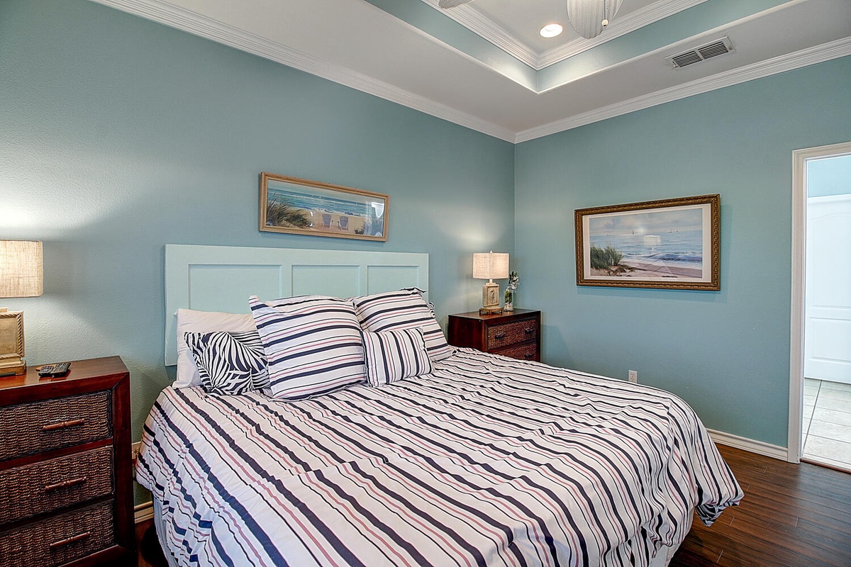 Drift off in your coastal-themed bedroom with calming blue walls, crisp linens, and charming artwork that brings seaside tranquility to your stay.