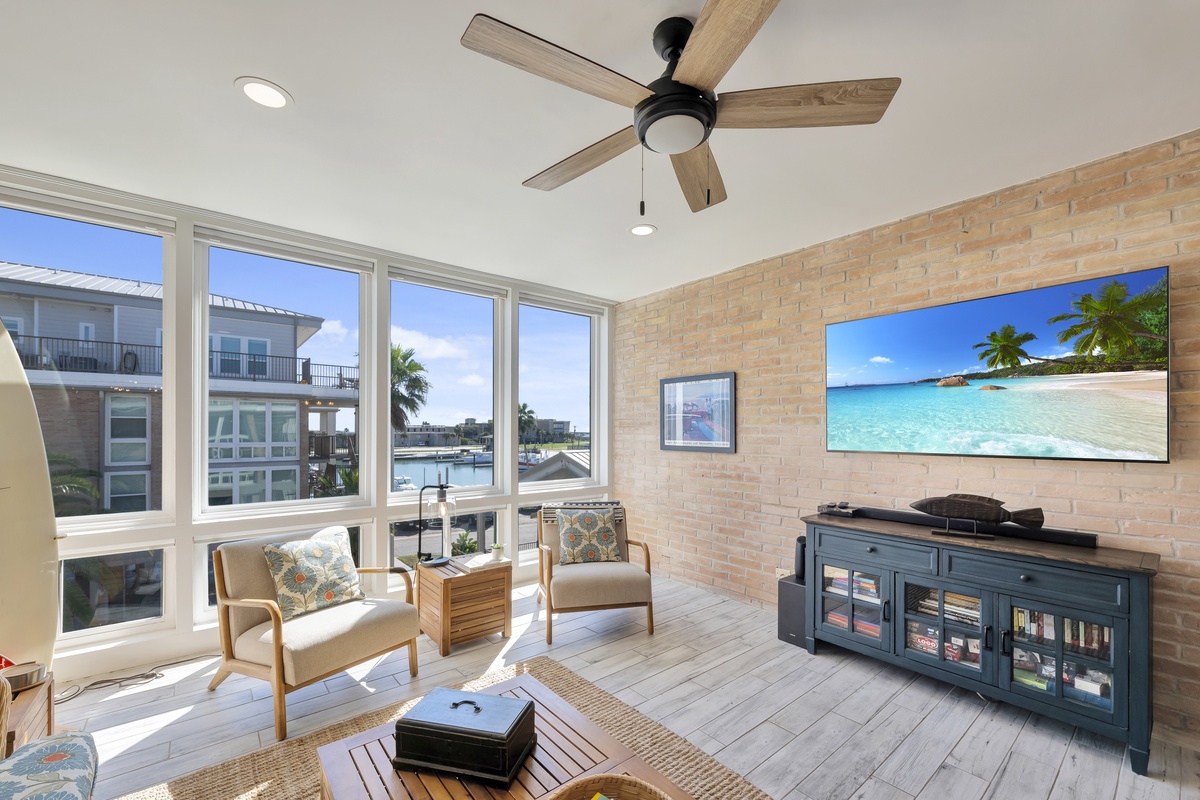 Relax in your bright living space with exposed brick walls, ceiling fan, and large windows overlooking the waterfront community.