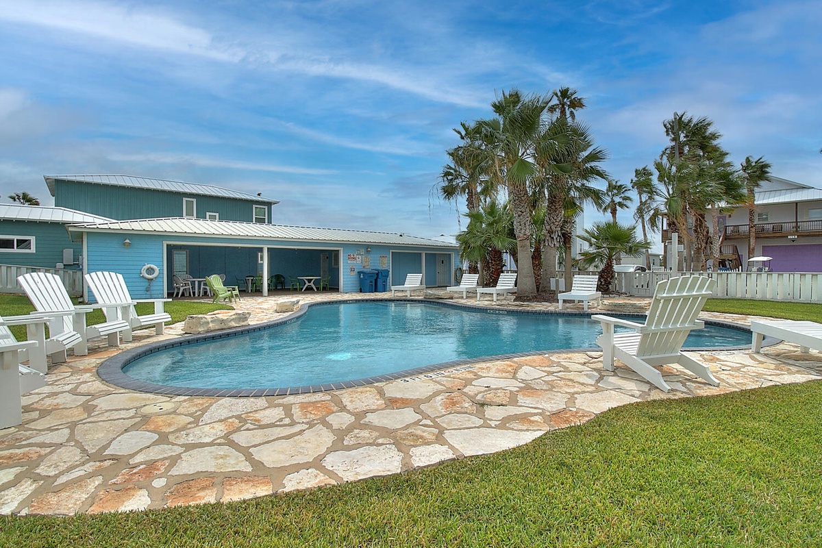 Dive into your private oasis with this sparkling pool surrounded by swaying palms and comfortable loungers for endless relaxation.