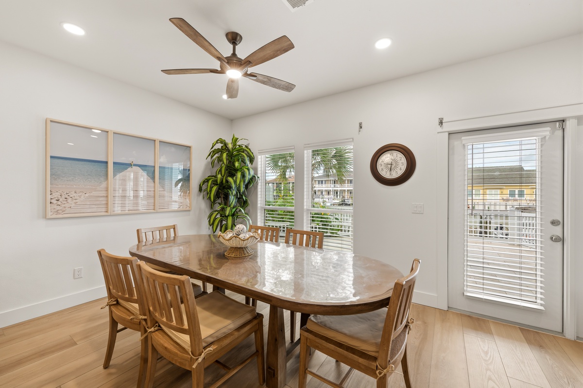 Gather around the spacious dining table for meals with your crew, bathed in natural light streaming through the windows. The ceiling fan keeps things comfortable, and sliding glass doors open to your private outdoor space.
