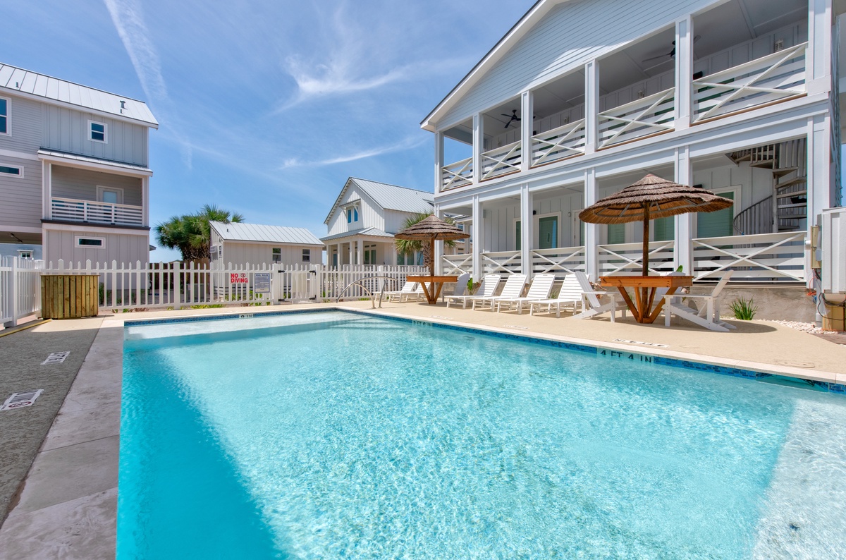 Dive into community pool oasis, where crystal-clear waters and thatched umbrellas create the perfect backdrop for sunny relaxation.