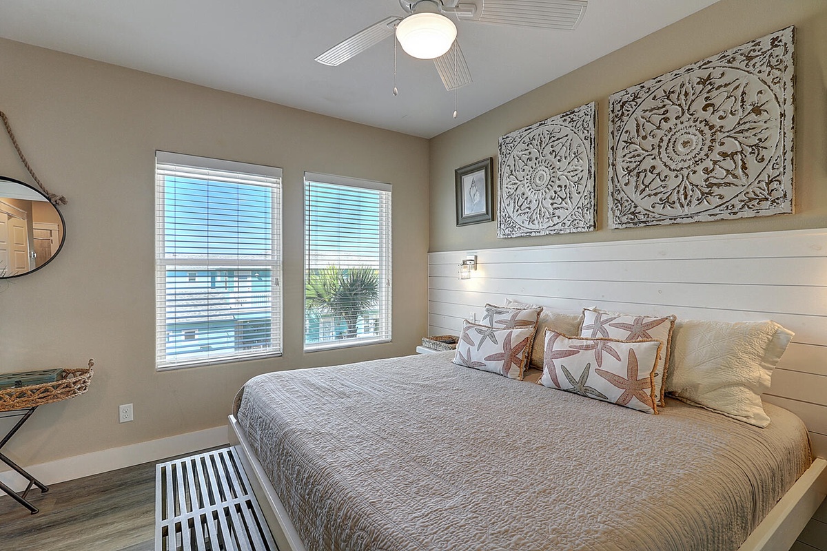 Sink into this cozy bedroom where coastal charm meets comfort. You'll love the nautical star pillows and shiplap accent wall.