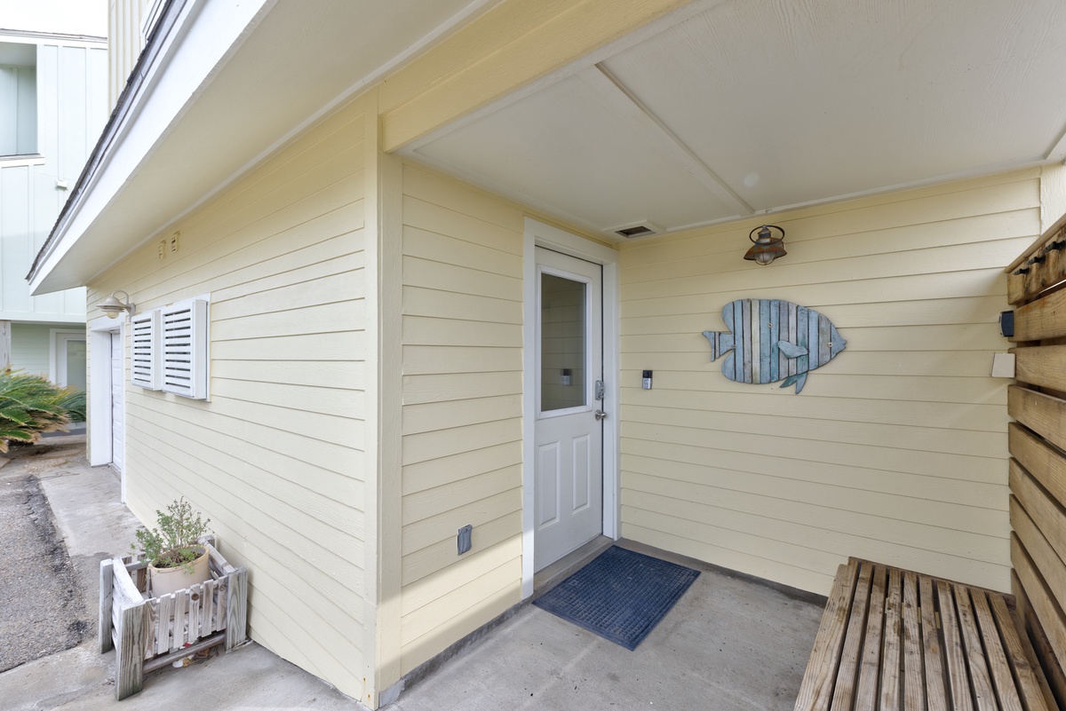 Welcome to your charming coastal retreat featuring a covered entrance with nautical fish art and thoughtful details.