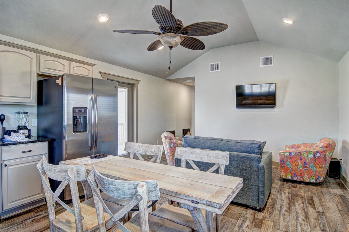 Relax in your bright open-concept space with tropical ceiling fan, modern kitchen, and cozy dining area perfect for memorable meals together.