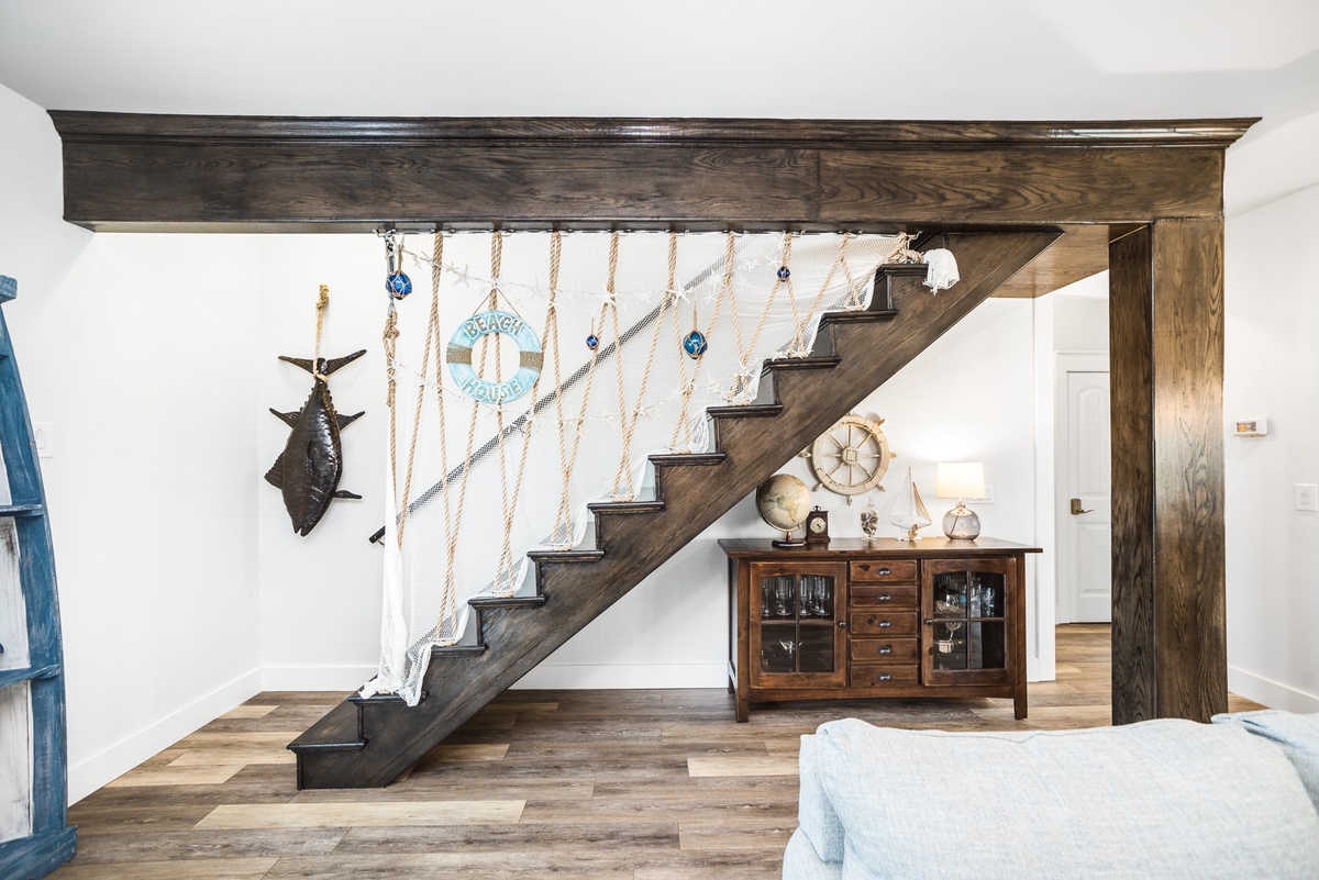 Your coastal retreat features rustic wood beams and nautical charm, with decorative netting and maritime touches creating a relaxing seaside atmosphere.