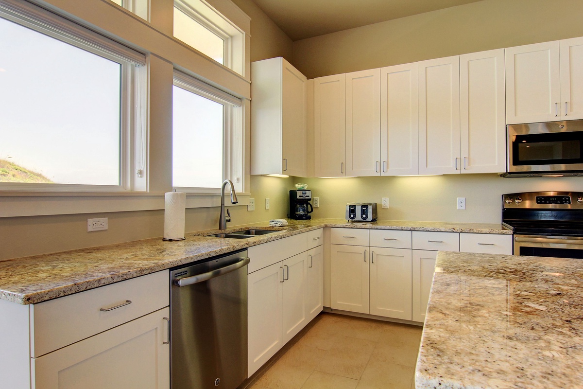 Your fully equipped kitchen features granite countertops, stainless steel appliances, and bright natural light for preparing memorable meals together.