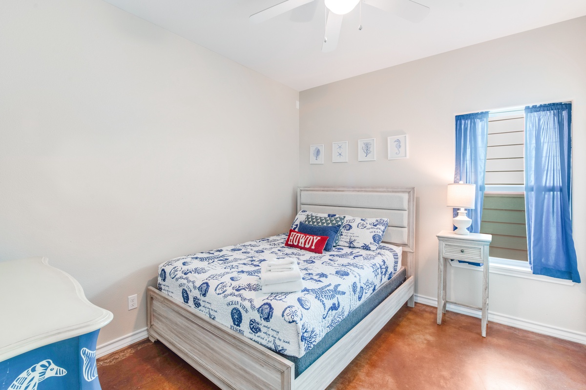 Drift off to sleep in your coastal-themed bedroom featuring nautical bedding and cheerful blue accents throughout.