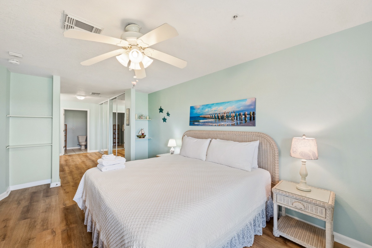 Slip into soft coastal comfort in your serene bedroom, where gentle aqua tones and crisp linens invite your most restful nights. The ceiling fan keeps you cool while beach-inspired touches complete your peaceful retreat.