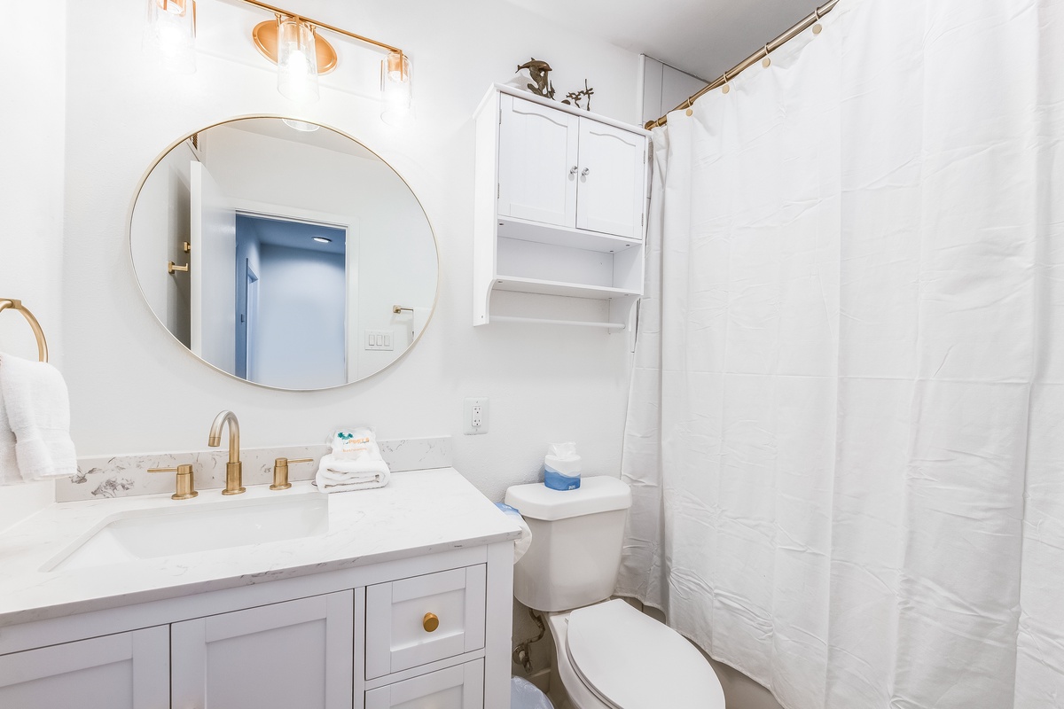 Step into your pristine bathroom featuring elegant gold fixtures, marble countertops, and a refreshing shower—your perfect retreat after a day of exploring.