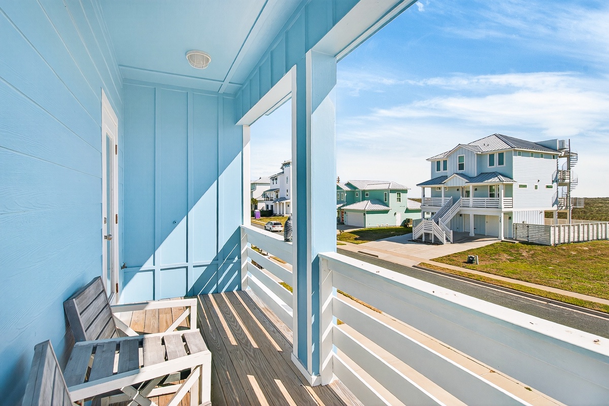 Relax on your private balcony with coastal charm, where morning coffee tastes better surrounded by cheerful blue walls and neighborhood views.