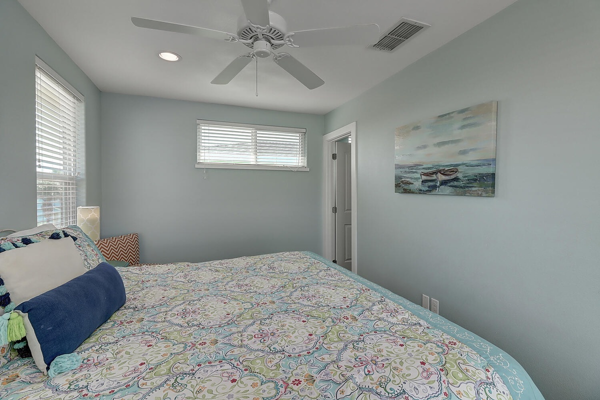 Drift to sleep in your calming coastal bedroom with soothing blue walls and gentle ceiling fan breezes.