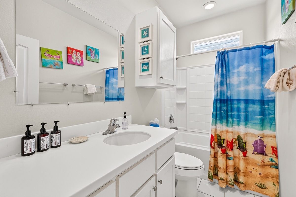 Your private bathroom features a bright vanity, colorful coastal touches, and a cheerful beach-inspired design.
