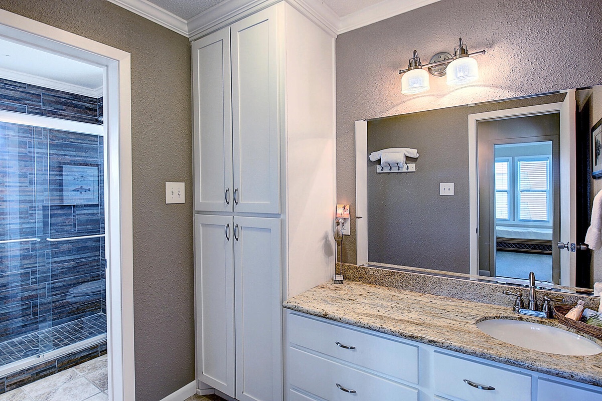 Step into your elegant bathroom retreat with granite counters and spacious vanity storage for all your essentials.