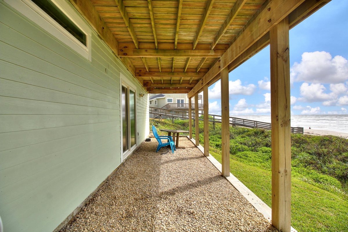 Covered porch with ocean views offers peaceful outdoor relaxation steps from the beach.
