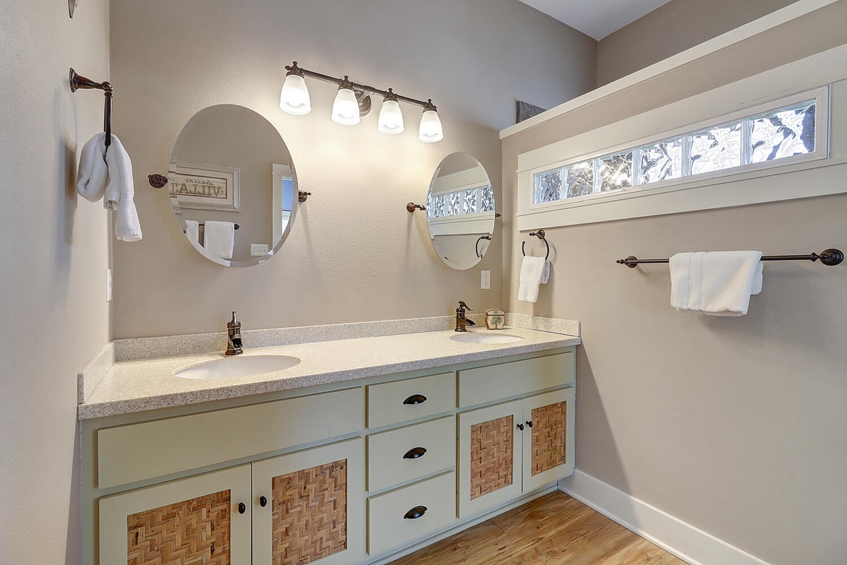 Freshen up at your spacious dual-vanity bathroom with modern fixtures, elegant lighting, and plenty of towel storage for two.