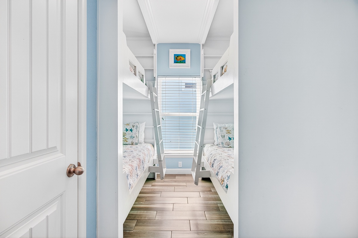 Your coastal retreat features charming bunk beds with ocean-themed linens and plenty of natural light streaming through shuttered windows.