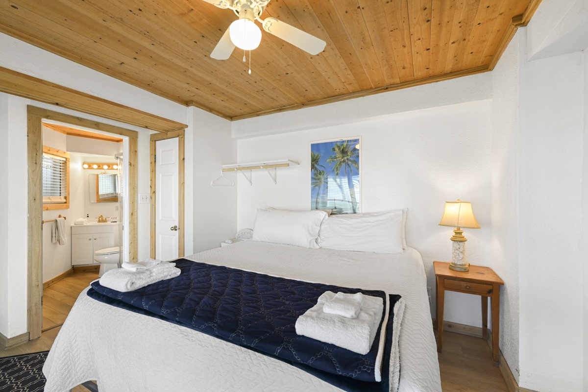 Wake up refreshed under warm wood-beamed ceilings in your cozy bedroom, complete with fresh linens and en-suite access for your convenience.