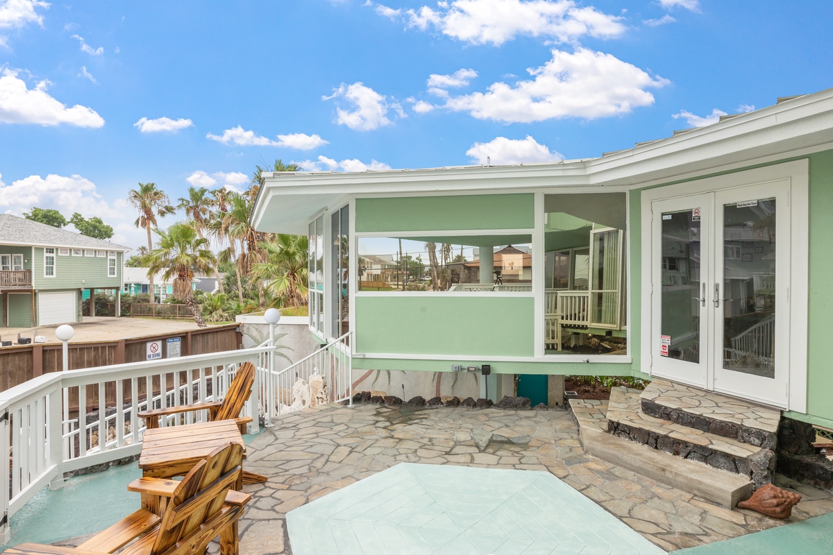 Step onto your private patio with stone flooring and wooden seating, perfect for morning coffee or sunset relaxation.