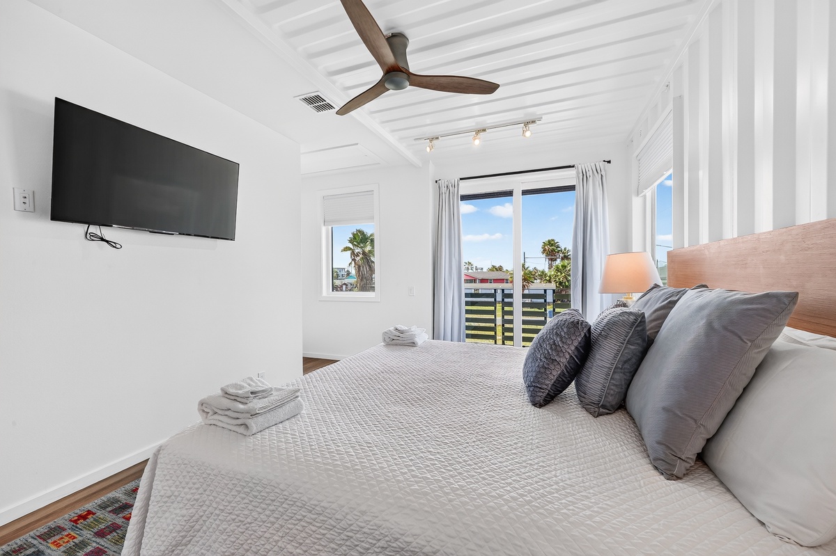 Sink into your plush king bed beneath the gentle breeze of the ceiling fan in your primary bedroom with sunny skies framed perfectly through your window.