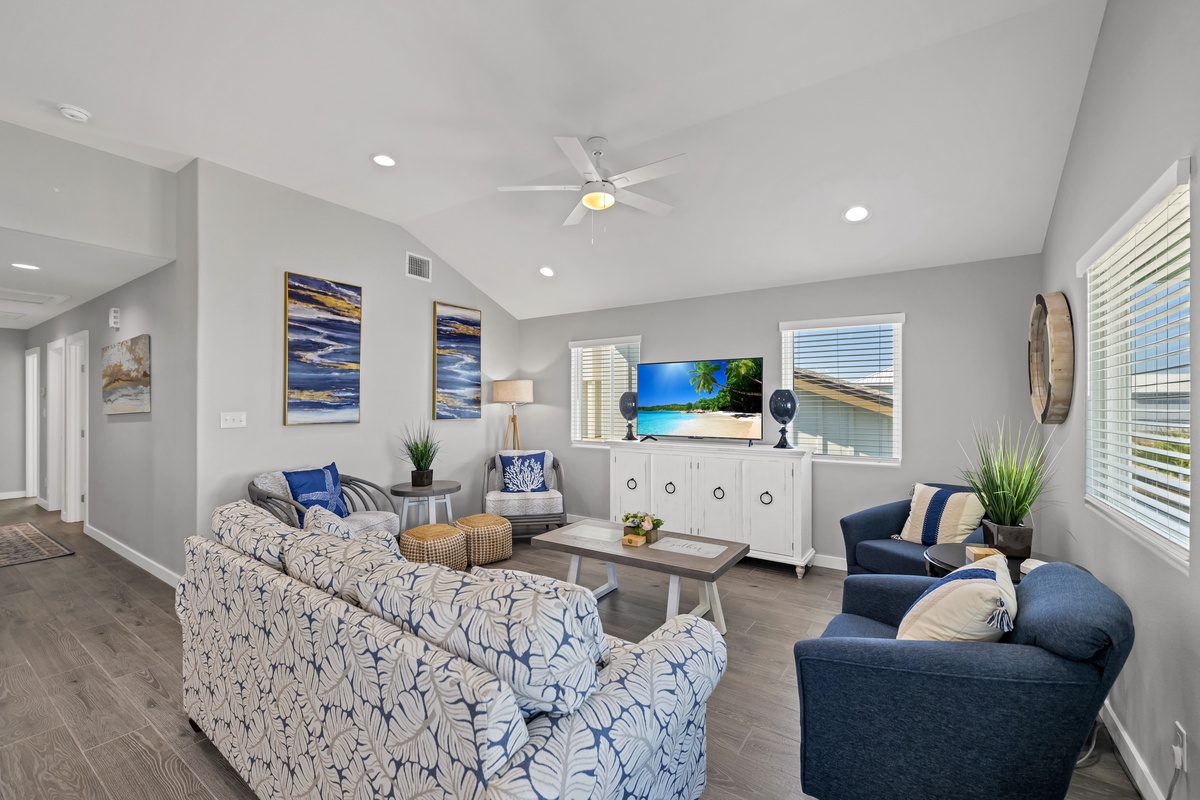 Relax in your spacious living room featuring modern coastal decor, comfortable seating, and a large TV perfect for unwinding after your adventures.