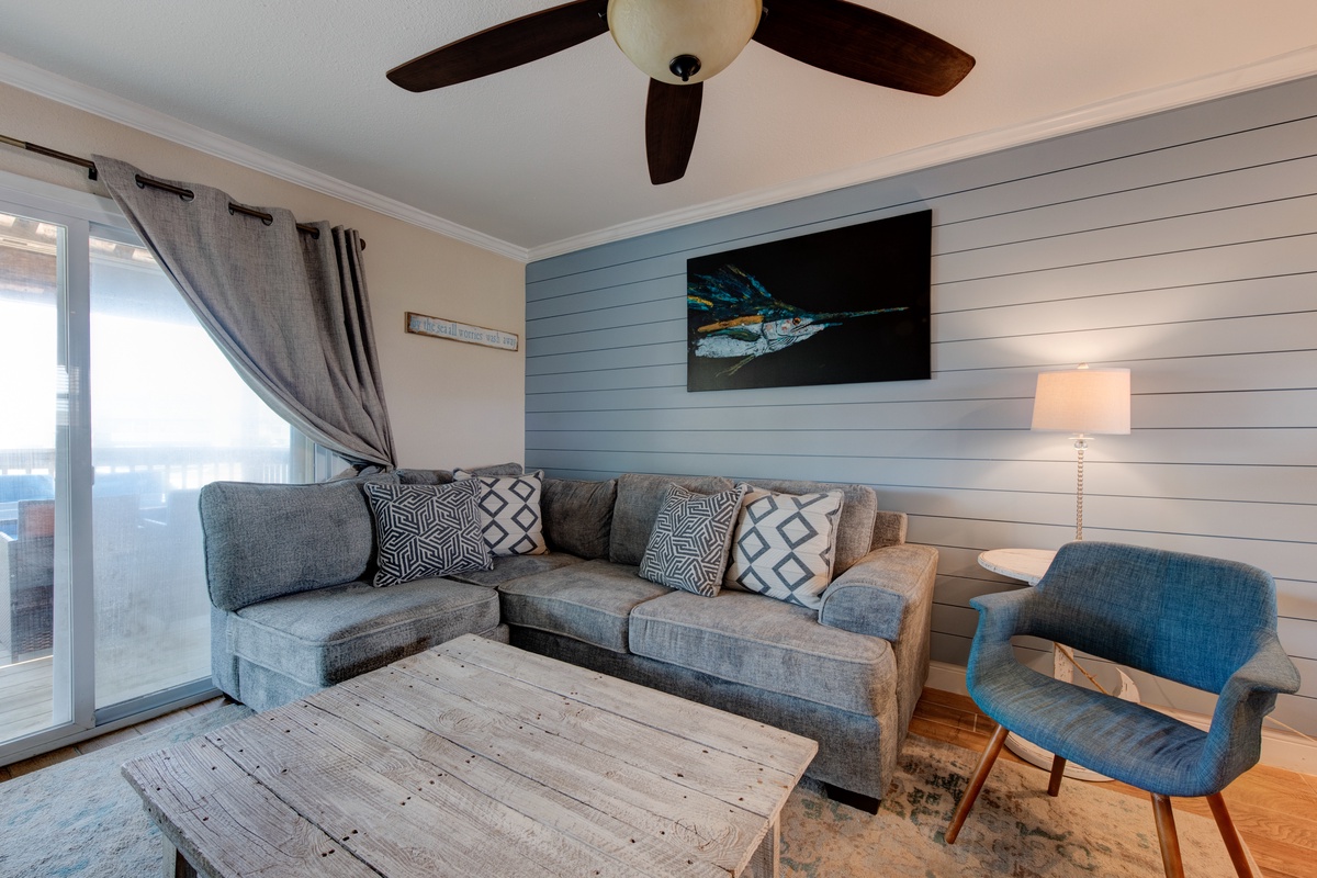 Relax in your stylish coastal living room with plush sectional seating, modern decor, and peaceful water views through floor-to-ceiling windows.