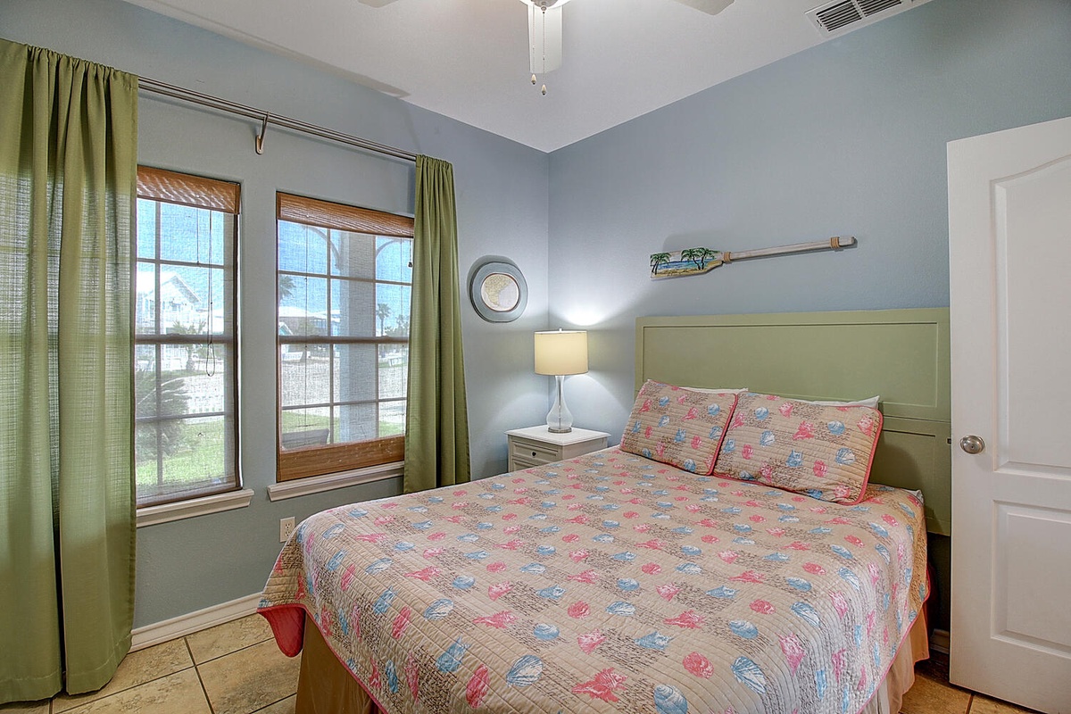 Your peaceful bedroom sanctuary features soft blue walls and colorful quilted bedding, creating the perfect retreat after exploring.