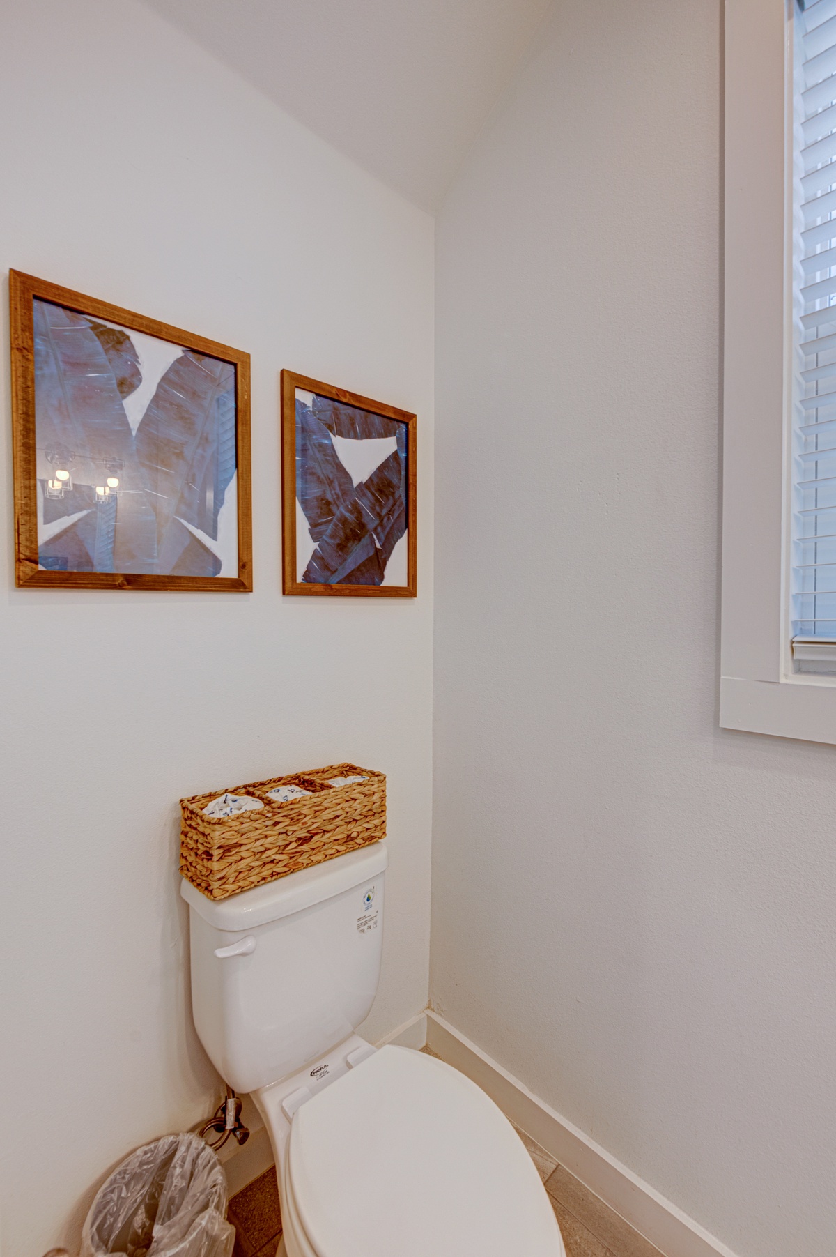 Your private powder room features thoughtful touches like coastal artwork and a wicker basket for your essentials.