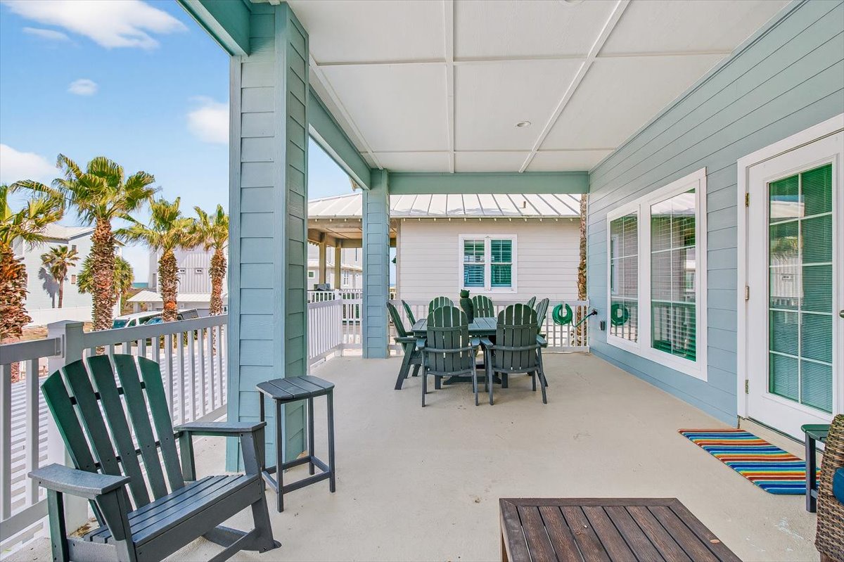 Your covered porch offers the perfect spot to sip morning coffee in Adirondack chairs while palm trees sway nearby.