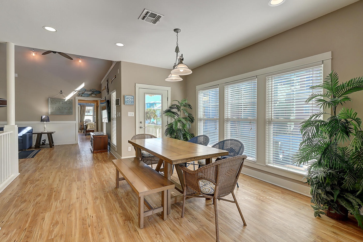 Gather around your spacious dining table surrounded by warm wood tones and natural light streaming through large windows.