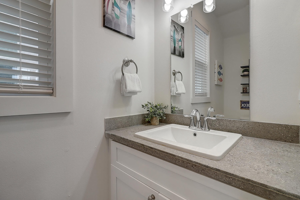 Refresh in your private bathroom with granite counters, crisp white vanity, and natural light streaming through plantation shutters.