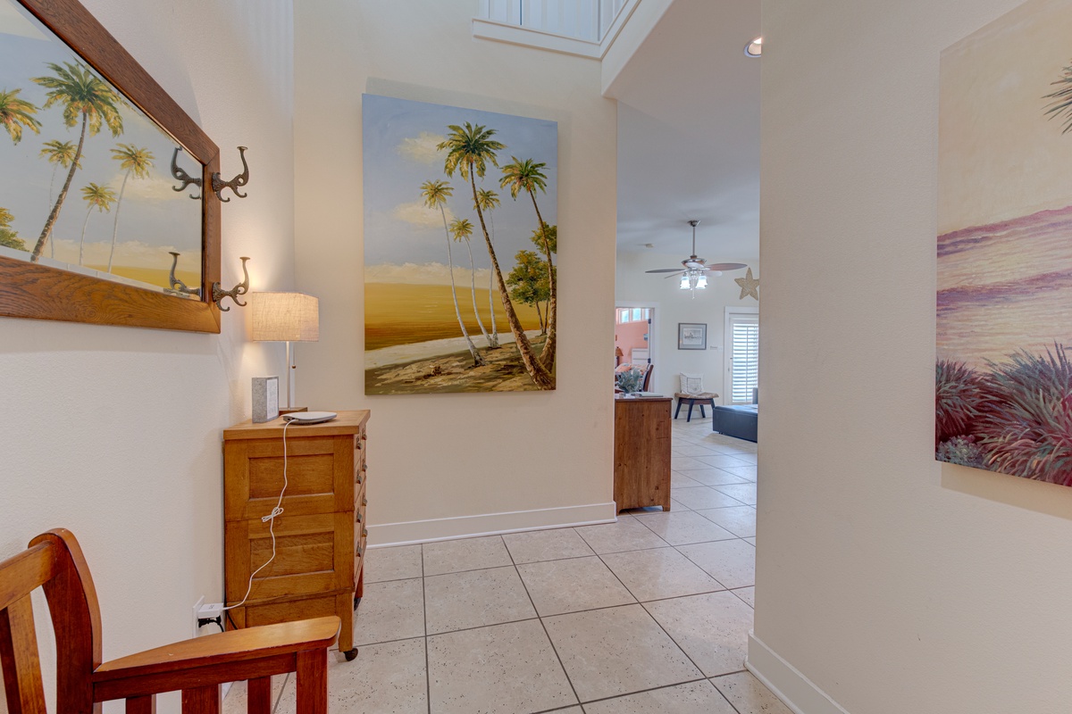 Step into your bright, tropical-themed entryway where cheerful palm tree artwork sets the perfect vacation mood for your stay.