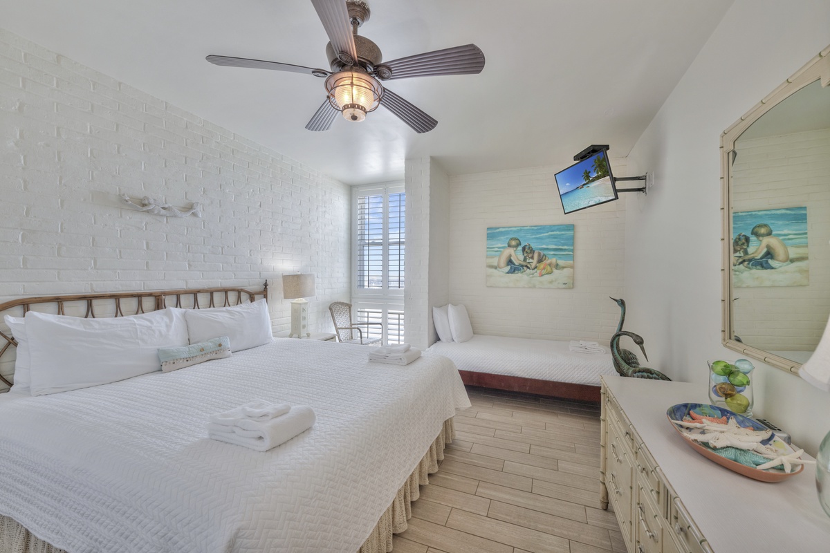 Drift off to sleep in your coastal-themed bedroom with crisp linens, ocean artwork, and gentle ceiling fan breeze.