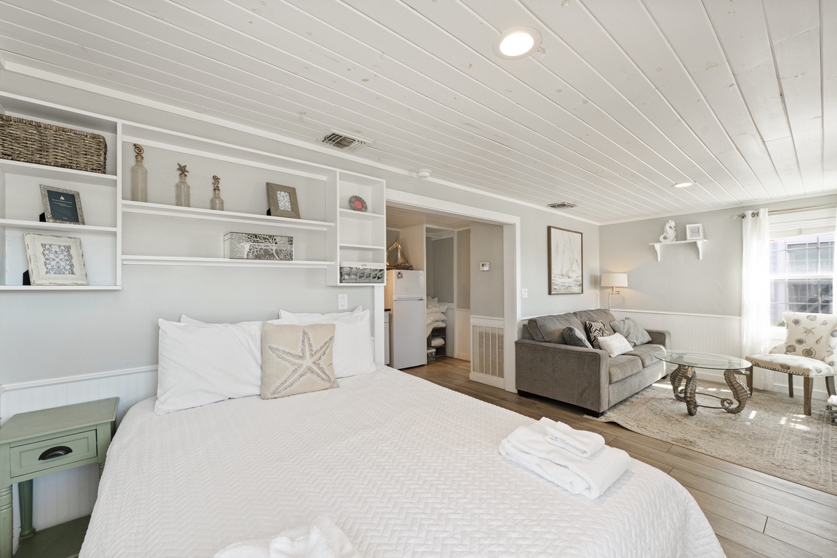 Unwind in your coastal-inspired retreat with built-in shelving, plush seating area, and fresh towels awaiting your arrival.