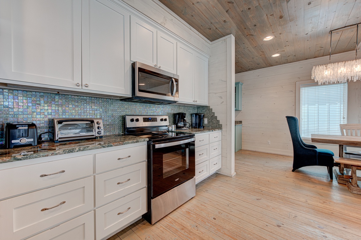 Your fully equipped kitchen features stainless steel appliances and stunning mosaic backsplash, perfect for preparing meals during your stay.