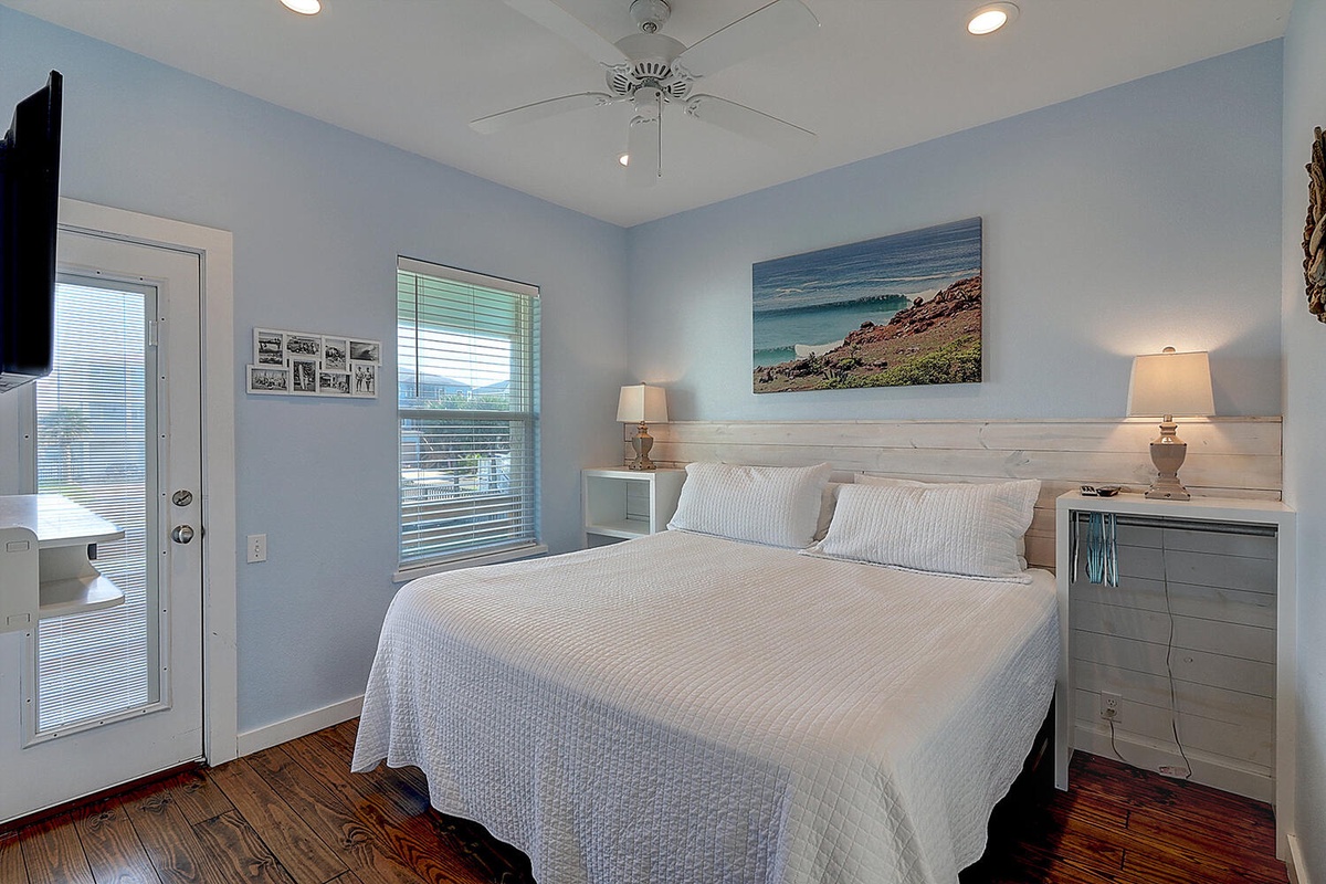 Drift off to sleep in your cozy coastal bedroom, where soft blue walls and ocean artwork create a peaceful seaside sanctuary.