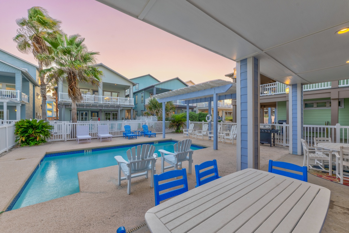 Your covered patio welcomes evening gatherings with outdoor dining, poolside lounging, and BBQ space as twilight paints the sky.