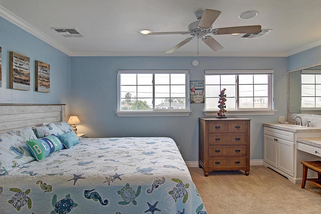 Drift off to dreamland in your serene coastal bedroom, where ocean-themed bedding and gentle blue walls create the perfect seaside sanctuary for restful nights.