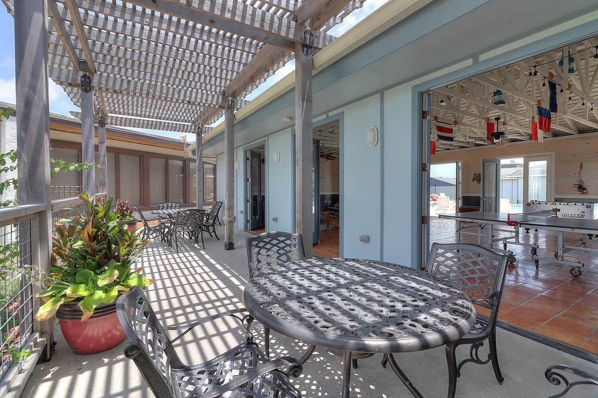 Relax on your private terrace with cast iron furniture under dappled pergola shade, where indoor-outdoor living flows seamlessly.