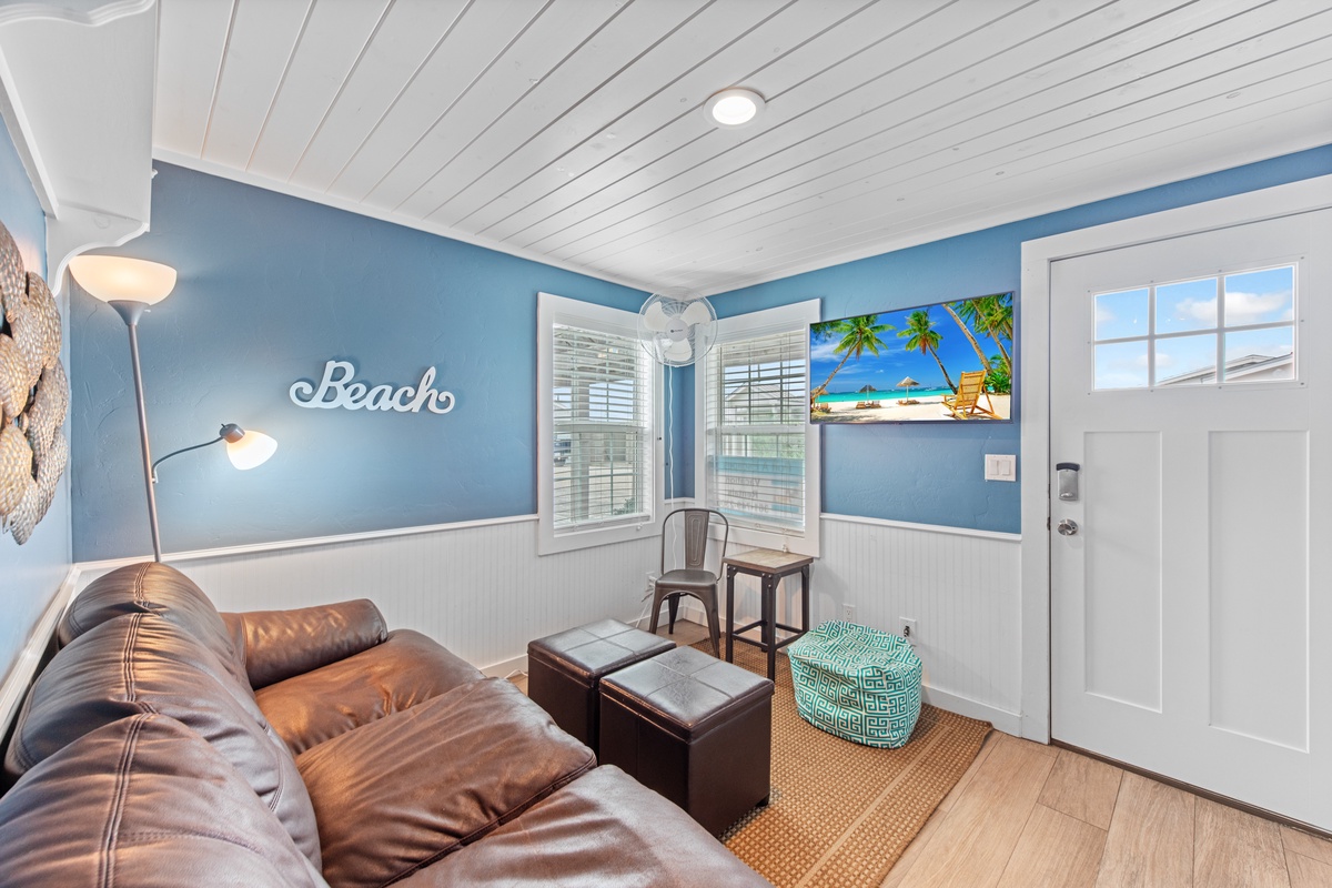 Unwind in your coastal-themed living space where ocean hues and comfortable leather seating create the perfect beach house atmosphere.