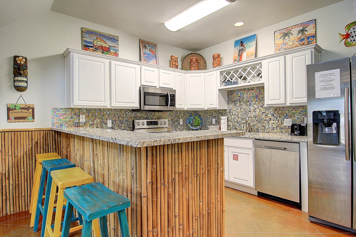 Your tropical-themed kitchen features vibrant bamboo details and colorful mosaic backsplash, perfect for preparing beachside meals.