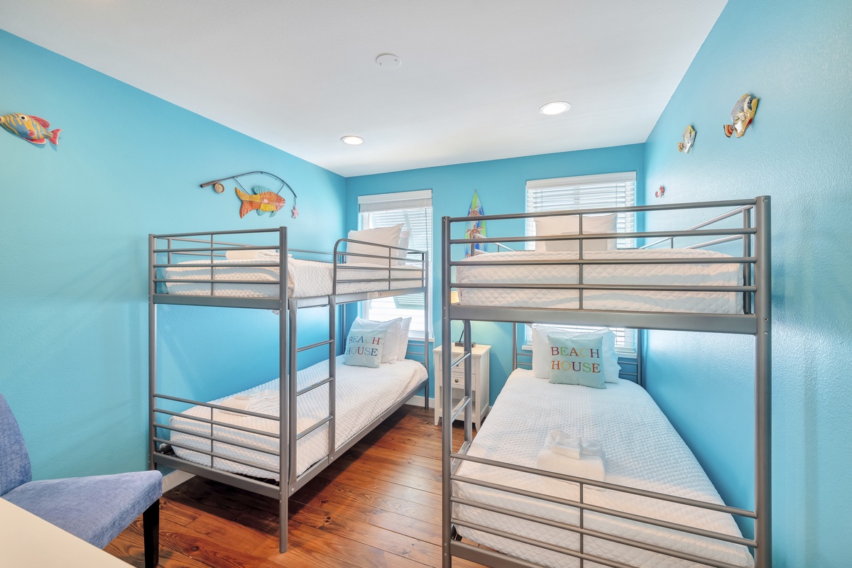 Sleep soundly in your bright ocean-themed bunk room, where playful fish decorations and cheerful blue walls create the perfect coastal retreat.