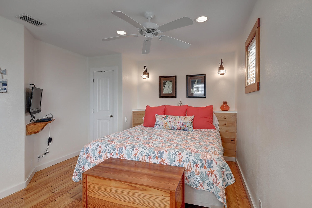 Drift off to sleep in your cozy bedroom, where soft coastal linens meet warm wood floors under gentle pendant lighting.