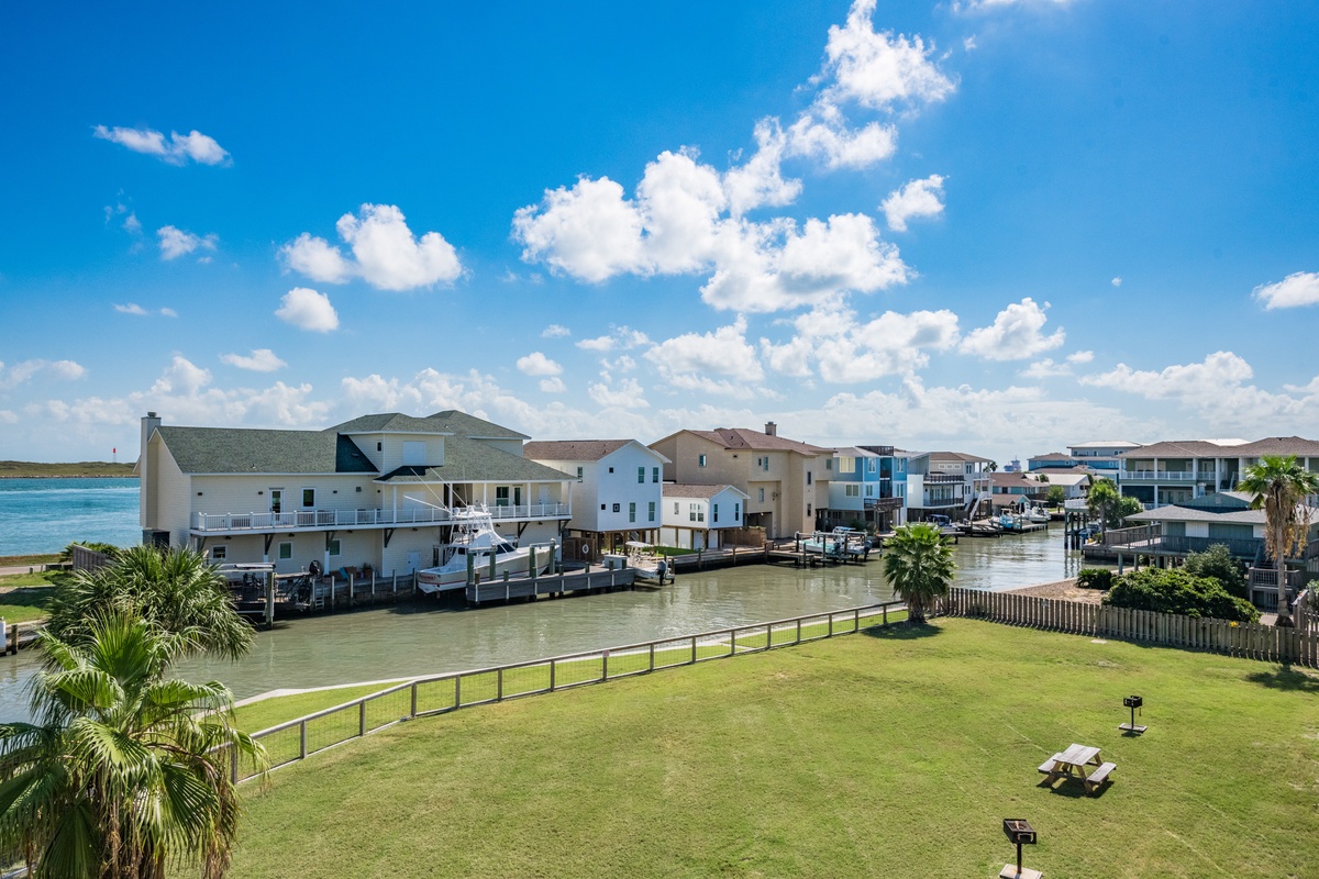 Waterfront community with canal access and private boat docks beneath a brilliant blue sky.