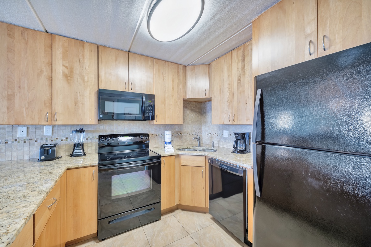 Your fully equipped kitchen features warm wood cabinetry and granite counters, perfect for preparing your favorite meals during your stay.
