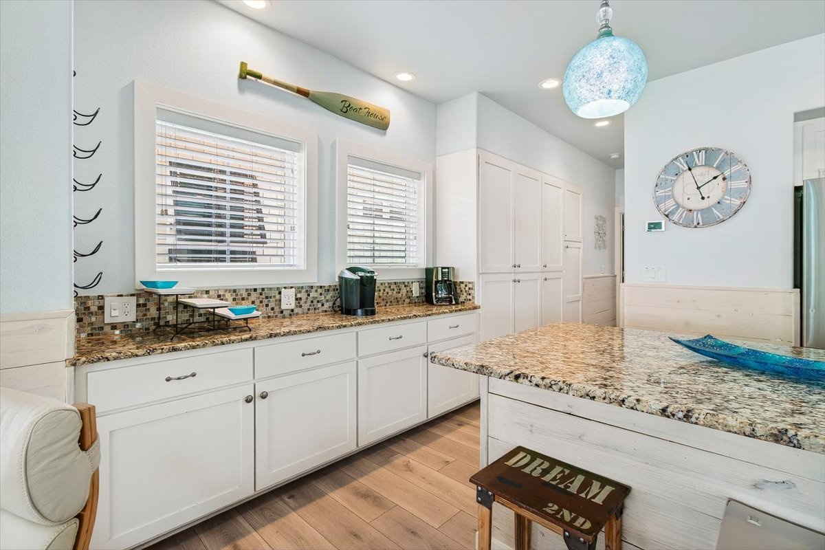 Cook your favorite meals in this bright, coastal-themed kitchen with granite countertops, modern appliances, and charming blue accents.