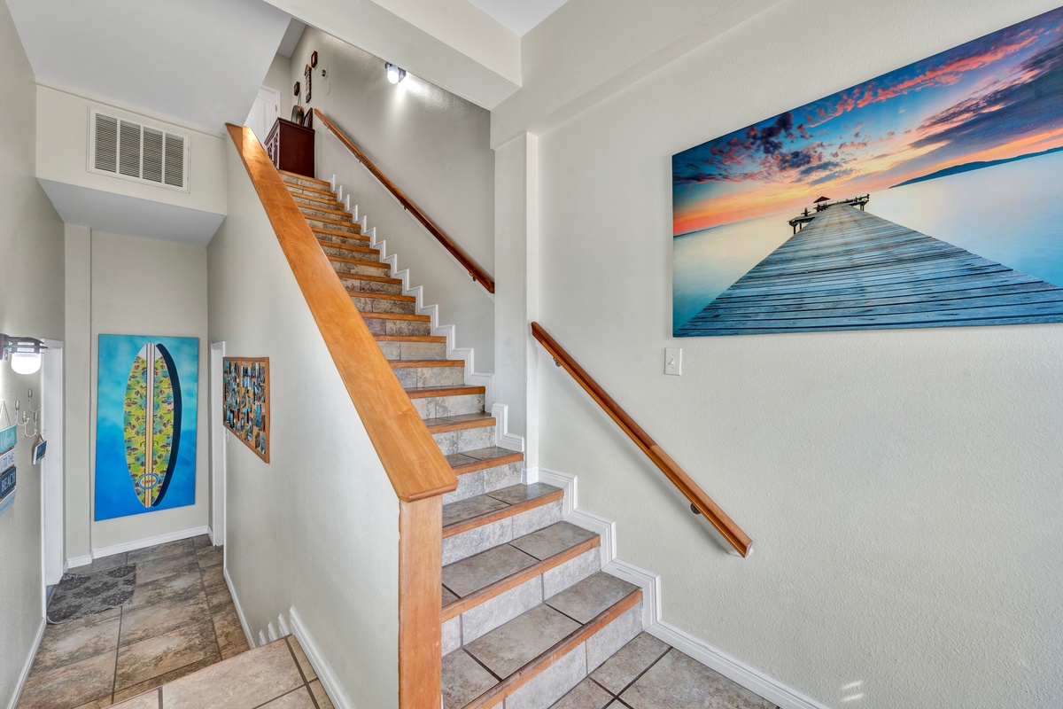 Step into your coastal sanctuary where stunning artwork and warm wood details create an inviting atmosphere throughout this beautifully designed space.