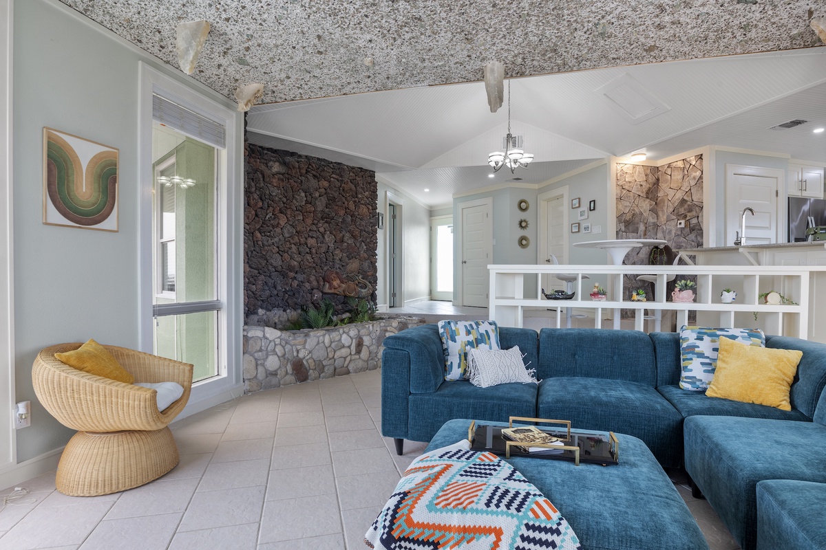Sink into the plush blue sectional and admire the stunning stone accent wall in this modern living space.